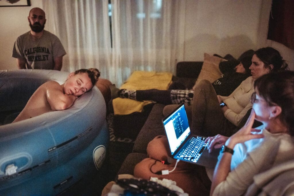 birth team sits by as sophia rests in the birth pool