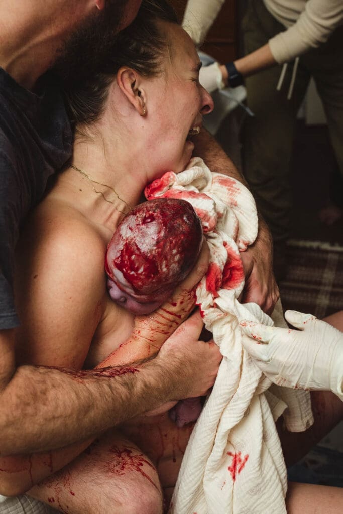 emotion and overwhelm as sophia takes in the moment of birth